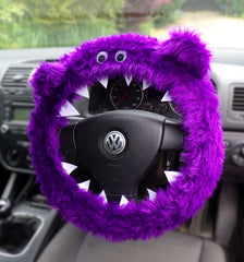 Purple Fuzzy monster steering wheel cover with Googly eyes, ears and felt teeth on a volkswagen steering wheel handmade by Poppys Crafts