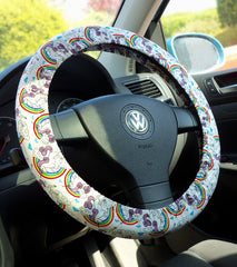Steering wheel cover with unicorn and rainbow pattern on a white background, handmade by Poppys Crafts pictured on a Volkswagen steering wheel